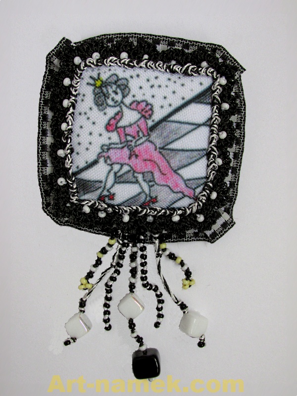 Brooch made of fiber with print, with lace, crochet trim and pendants from beads.